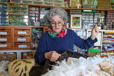 Artisane cousant une pièce de costume en fourrure dans son atelier